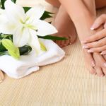 Woman hand and feet with manicure and Lily