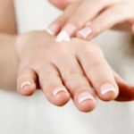 Beautiful woman’s hands applying cream