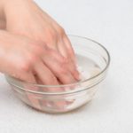 Hands in water with seashells